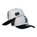 Gorra Monastery Blanca con Bordado de Astronauta y Placa Metálica.