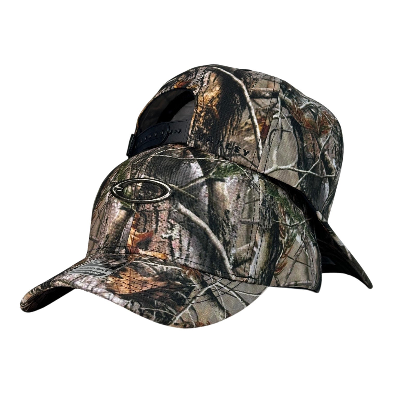 Gorra Oakley Camo con aplique metálico y cierre ajustable.